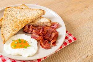 stekt ägg med rostat bröd och bacon till frukost foto