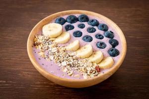 yoghurt eller smoothieskål med blåbär, banan och granola - hälsosam matstil foto
