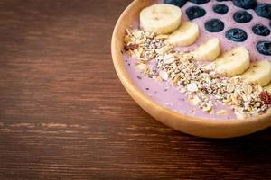 yoghurt eller smoothieskål med blåbär, banan och granola - hälsosam matstil foto