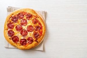 pepperoni pizza på träbricka - italiensk matstil foto