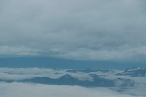 berg räckvidd med synlig silhuetter genom de morgon- blå dimma. foto