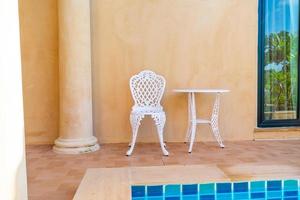tom vit stol och bord på sidan av poolen foto