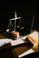 lag juridisk teknik koncept. domareklubban på datorn med rättvisans skalor på advokatens skrivbord. foto