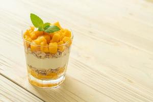 färsk mango yoghurt med granola i glas - hälsosam matstil foto