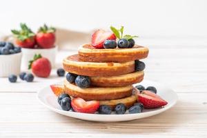 souffelpannkaka med färska blåbär, färska jordgubbar och honung foto