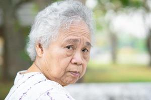 asiatisk senior eller äldre gammal damkvinna som sitter i park, hälsosamt starkt medicinskt koncept. foto