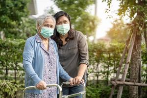asiatisk senior eller äldre gammal damkvinna som bär en ansiktsmask ny normal i park för att skydda säkerhetsinfektion covid-19 coronavirus. foto