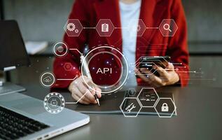 api Ansökan programmering gränssnitt, kvinna använder sig av bärbar dator, läsplatta och smartphone med virtuell skärm api ikon programvara utveckling verktyg, modern teknologi och nätverkande begrepp. foto