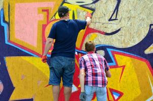 Kharkov, ukraina - Maj 27, 2017 festival av gata konst. ung grabbar dra graffiti på bärbar trä- väggar i de Centrum av de stad. de bearbeta av målning på väggar med aerosol spray burkar foto