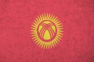 kyrgyzstan flagga avbildad i ljus måla färger på gammal lättnad putsning vägg. texturerad baner på grov bakgrund foto