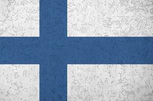 finland flagga avbildad i ljus måla färger på gammal lättnad putsning vägg. texturerad baner på grov bakgrund foto