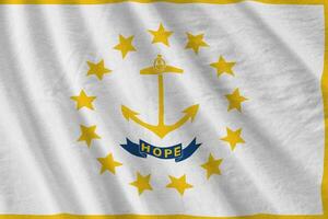 Rhode ö oss stat flagga med stor veck vinka stänga upp under de studio ljus inomhus. de officiell symboler och färger i baner foto
