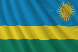rwanda flagga med stor veck vinka stänga upp under de studio ljus inomhus. de officiell symboler och färger i baner foto
