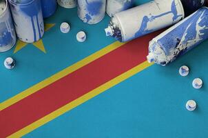 demokratisk republik av de kongo flagga och få Begagnade aerosol spray burkar för graffiti målning. gata konst kultur begrepp foto