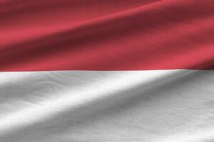 indonesien flagga med stor veck vinka stänga upp under de studio ljus inomhus. de officiell symboler och färger i baner foto