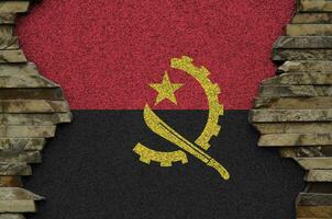 angola flagga avbildad i måla färger på gammal sten vägg närbild. texturerad baner på sten vägg bakgrund foto