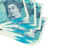 5 brittiskt pounds räkningar lögner i små knippa eller packa isolerat på vit. attrapp med kopia Plats. företag och valuta utbyta foto
