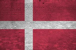 Danmark flagga avbildad i måla färger på gammal tegel vägg. texturerad baner på stor tegel vägg murverk bakgrund foto