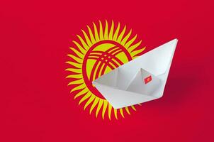 kyrgyzstan flagga avbildad på papper origami fartyg närbild. handgjort konst begrepp foto