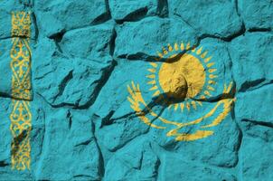 kazakhstan flagga avbildad i måla färger på gammal sten vägg närbild. texturerad baner på sten vägg bakgrund foto