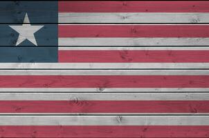 Liberia flagga avbildad i ljus måla färger på gammal trä- vägg. texturerad baner på grov bakgrund foto