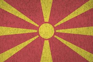 macedonia flagga avbildad i ljus måla färger på gammal lättnad putsning vägg. texturerad baner på grov bakgrund foto