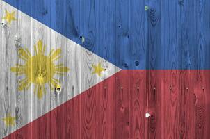 filippinerna flagga avbildad i ljus måla färger på gammal trä- vägg. texturerad baner på grov bakgrund foto