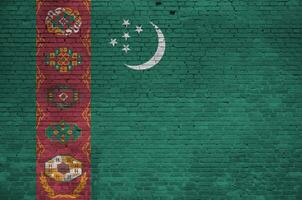 turkmenistan flagga avbildad i måla färger på gammal tegel vägg. texturerad baner på stor tegel vägg murverk bakgrund foto