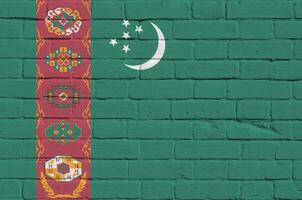 turkmenistan flagga avbildad i måla färger på gammal tegel vägg. texturerad baner på stor tegel vägg murverk bakgrund foto