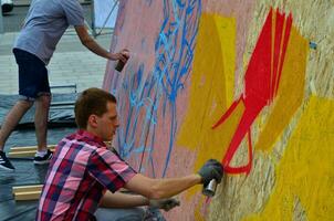 Kharkov, ukraina - Maj 27, 2017 festival av gata konst. ung grabbar dra graffiti på bärbar trä- väggar i de Centrum av de stad. de bearbeta av målning på väggar med aerosol spray burkar foto