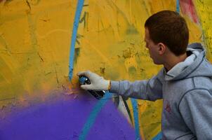 Kharkov, ukraina - Maj 27, 2017 festival av gata konst. ung grabbar dra graffiti på ett gammal betong väggar i de Centrum av de stad. de bearbeta av målning på väggar med aerosol spray burkar foto