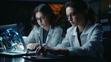 två kvinna vetenskapsmän är använder sig av bärbara datorer i de laboratorium. foto