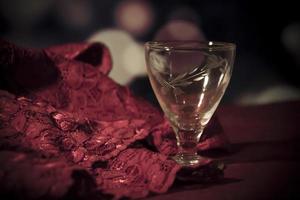 sensuell röd spets och ett tomt konjakglas på ett bord