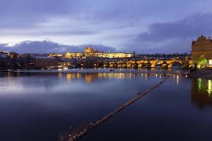 natt färgrik snöig jul prag mindre stad med gotiskt slott och charles bridge, tjeckien foto