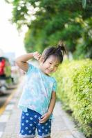 porträtt av glad liten flicka står ing i parken foto