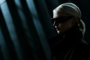 en kvinna bär solglasögon i en mörk rum foto