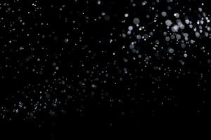 små droppar av regn, snö på en svart bakgrund. vind. naturlig bakgrund foto