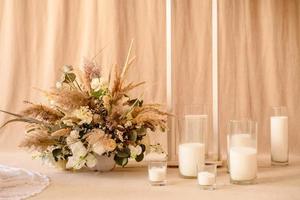 dekorationer från torra vackra blommor i en vit vas på en beige tygbakgrund