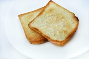 friterad rostat bröd på en vit tallrik. bakad bröd för smörgåsar. vegan mat. foto