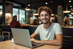 porträtt av glad manlig studerande inlärning uppkopplad i kaffe affär, ung europeisk man studier med bärbar dator i Kafé, håller på med läxa foto