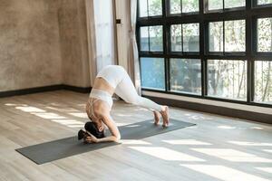 kondition asiatisk kvinna håller på med yoga stretching övning på matta yoga kondition övningar. friska livsstil stillhet och koppla av på yoga studio foto