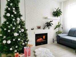 öppen spis och jul träd med presenterar i levande rum foto