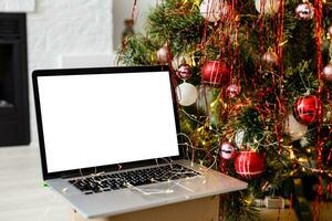 bärbar dator med gåva låda och jul lampor bakgrund foto