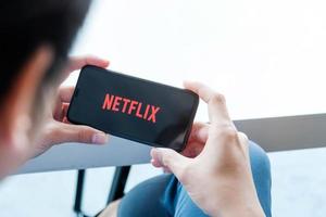 Chiang Mai, Thailand, 21 mars 2021 - man tittar på Netflix på en smartphone foto