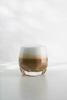 iced cappuccino i en plast glas på en vit trä- tabell foto
