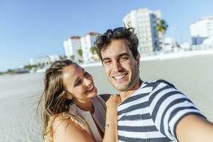 selfie av en Lycklig ung par på de strand foto