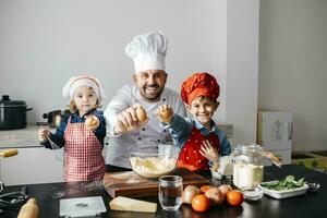 porträtt av far med två barn framställning deg i kök på Hem foto