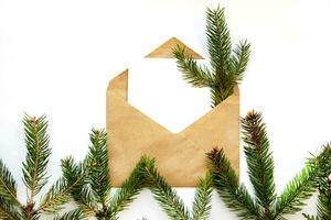 minimalistisk vykort layout med gran gren. kraft kuvert, platt lägga, topp se stänga upp. jul, Semester detaljer, dekoration, gåvor, förpackning. foto