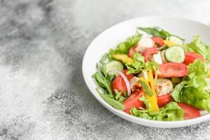 färsk läcker sallad med kyckling, tomat, gurka, lök och gröna med olivolja foto