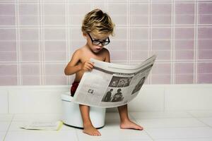 unge läsning tidning och toalett på pott. foto